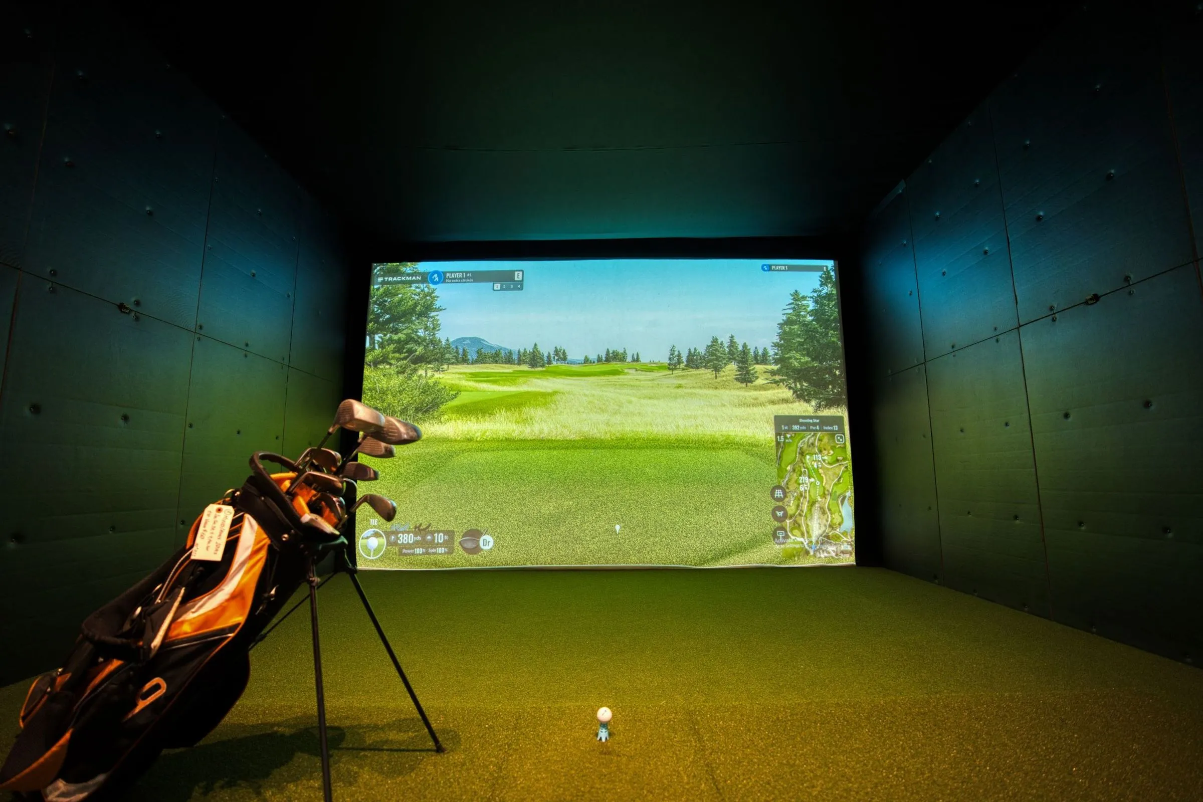 A simulator bay with the course on the big screen