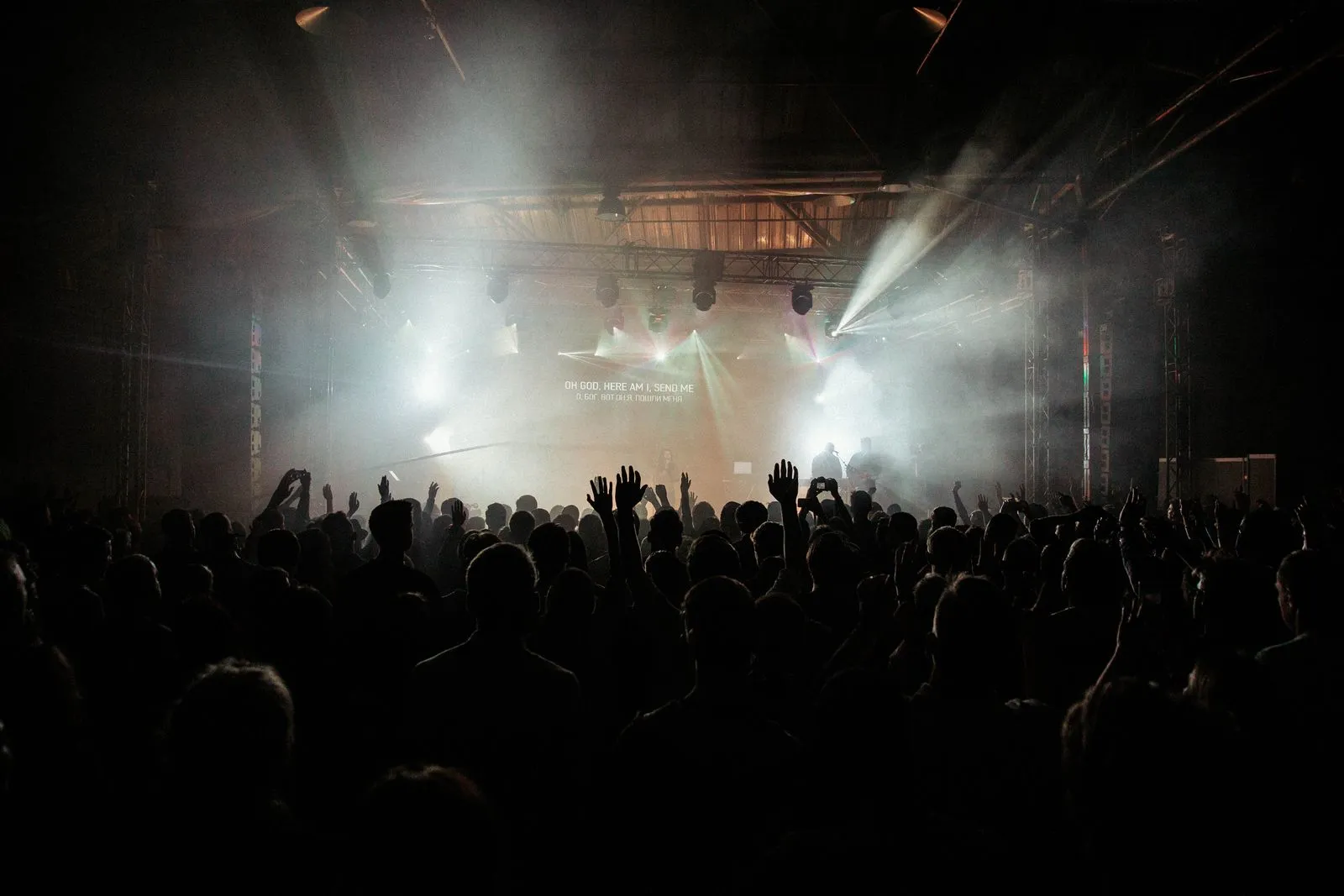 Crowd facing a smoky, lit stage