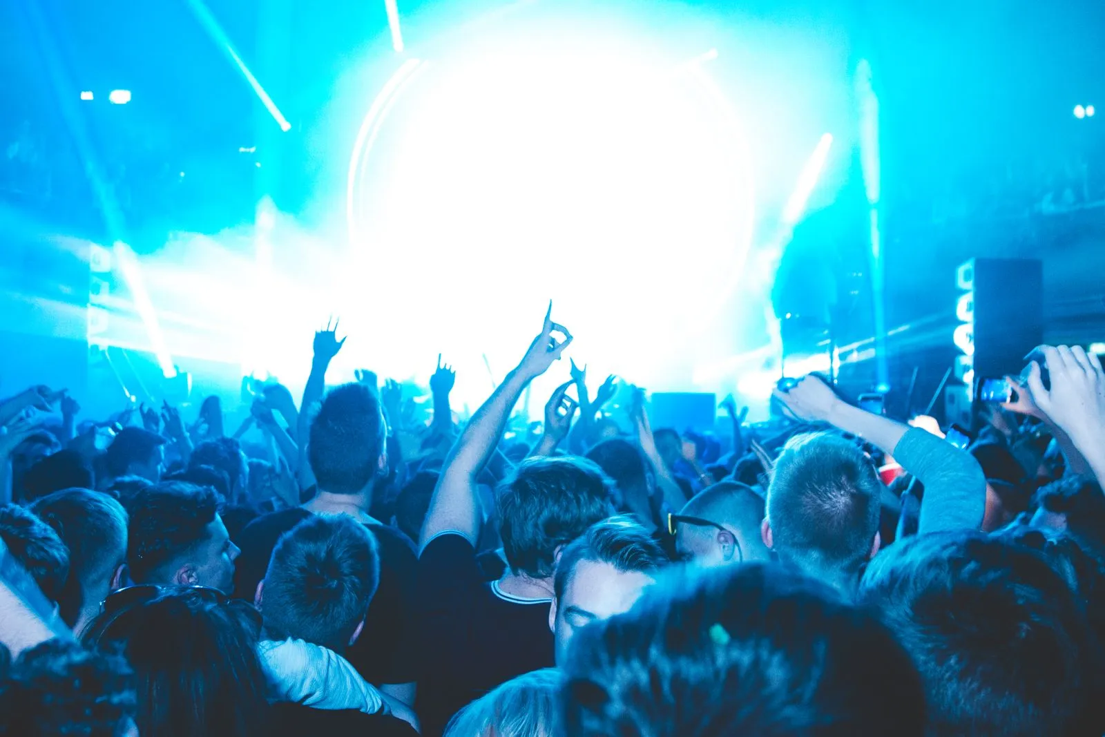 Blue light beams over a packed crowd